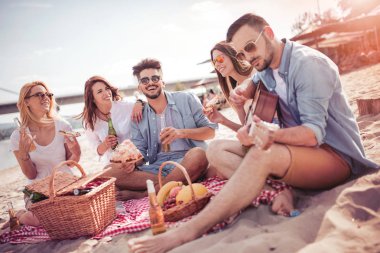 Gençlerin grup birlikte eğleniyor sahilde, piknik mutlu.