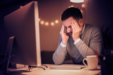 Adam evde dizüstü bilgisayarla çalışıyor.