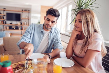 Mutfakta pizza yemek mutlu genç Çift.