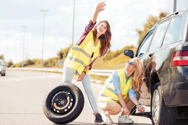 Deux filles sur la route essayant de réparer leur voiture . — Photo