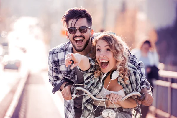 Jovem casal amoroso namoro enquanto andar de bicicleta. — Fotografia de Stock