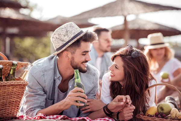 Happy couple lying on a blanket at the beach. — Stock Photo, Image