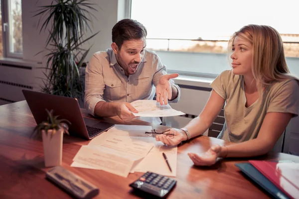 Pareja revisando sus facturas en la sala de estar en casa . — Foto de Stock