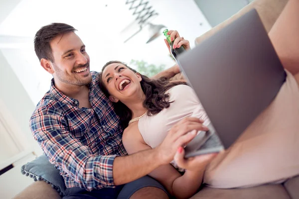 Giovane coppia rilassante sul divano con computer portatile — Foto Stock