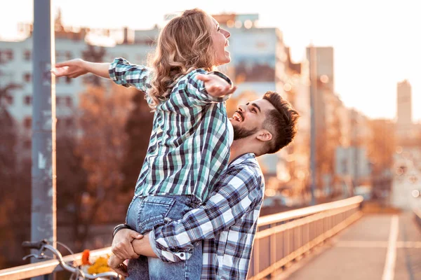 Feliz joven pareja abrazando y riendo al aire libre. — Foto de Stock