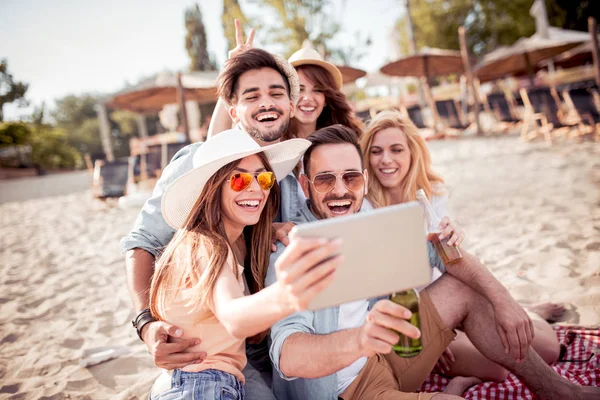 Grupp av glada vänner tar selfie tillsammans på stranden. — Stockfoto