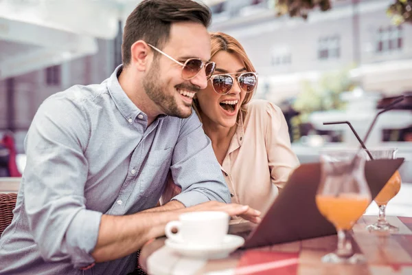 Paar unterhält sich und nutzt Laptop im Café. — Stockfoto