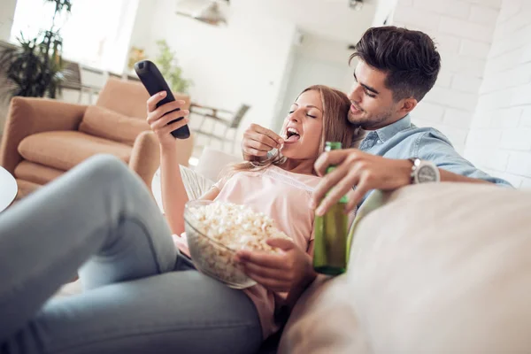 Pareja viendo televisión y comiendo palomitas de maíz . — Foto de Stock