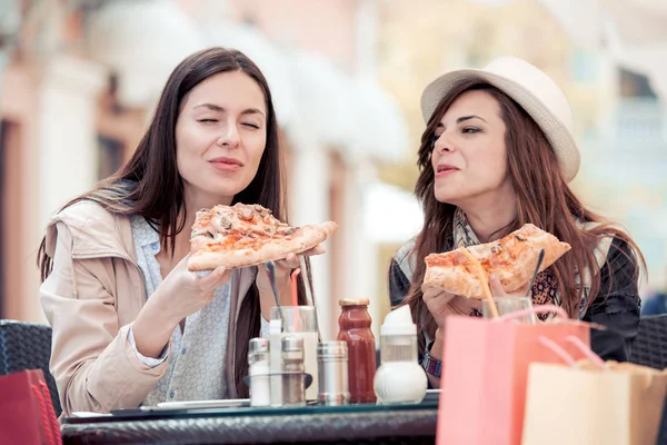 Két nő birtoklás móka, kávézó, pizzát eszik együtt. — Stock Fotó