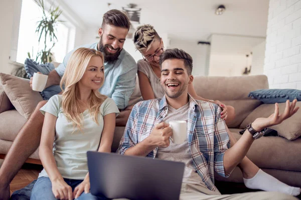 Grupo de amigos sentados en el sofá en el salón . — Foto de Stock