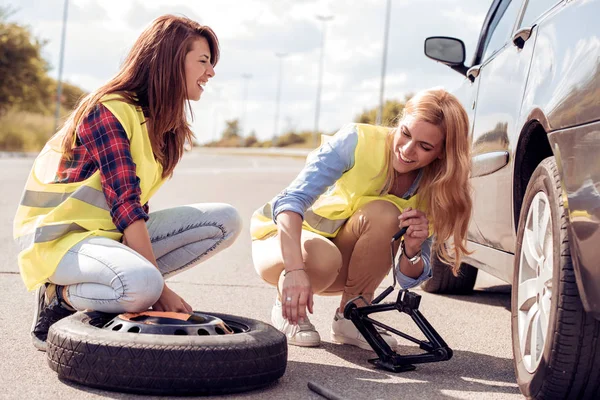 Deux filles sur la route essayant de réparer leur voiture . — Photo