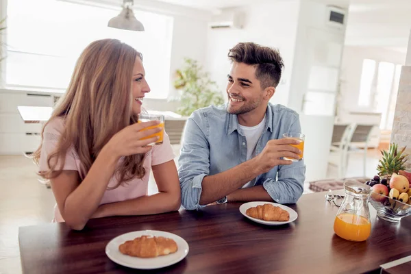 Fröhliches Paar frühstückt in der Küche. — Stockfoto