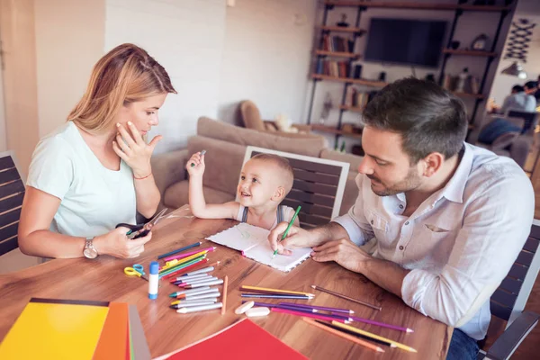 Padres jóvenes con dibujo de niño pequeño . — Foto de Stock