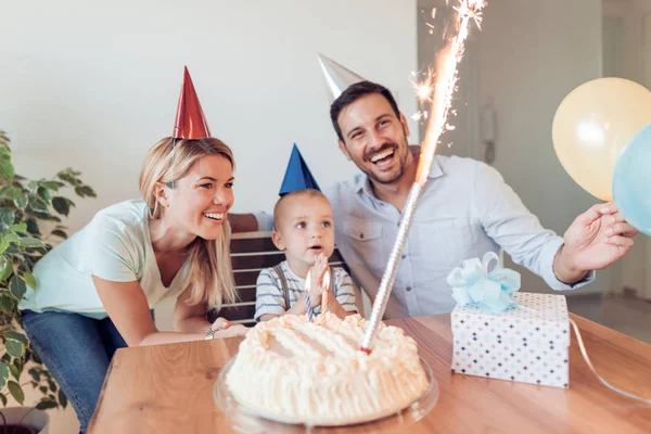 Piccolo ragazzo che soffia candele con la sua famiglia . — Foto Stock