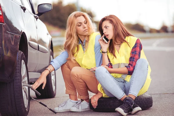 Deux filles sur la route essayant de réparer leur voiture . — Photo