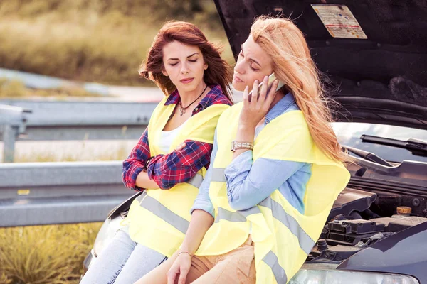 Deux filles sur la route essayant de réparer leur voiture . — Photo