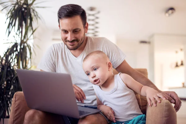 Padre e hijo mirando el portátil y sonriendo . — Foto de Stock