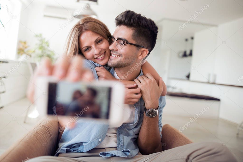 Portrait of a happy couple making selfie photo.