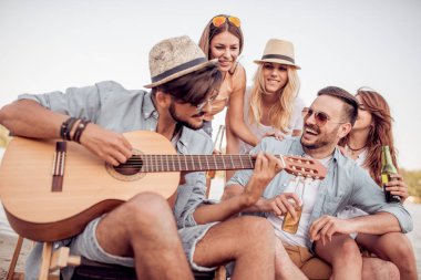 Bir grup insan birlikte eğleniyor sahilde, piknik mutlu.