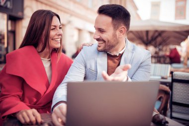 Kafede birlikte vakit ve dizüstü bilgisayarda çalışan mutlu çift.