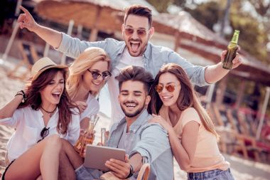 Selfie akıllı telefon ile birlikte sahilde alarak neşeli arkadaş grubu.