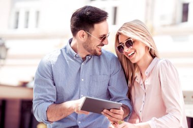 Genç çift dijital tablet vasıl birlikte arıyorum. Şehirde oturan ve having fun.