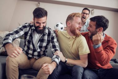 Pizza yeme ve soğuk bira içme sırasında evde TV izlerken arkadaşlar.