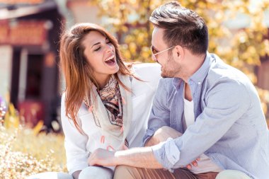 Dışarıda birbirine aşık gülümseyen bir çift. Sokakta sarılan mutlu genç bir çift..