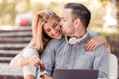 Dizüstü bilgisayar kullanarak kentsel konumda sonbahar güneşli günde iki. Modern eğlence kavramı ile yeni trendler ve teknoloji.