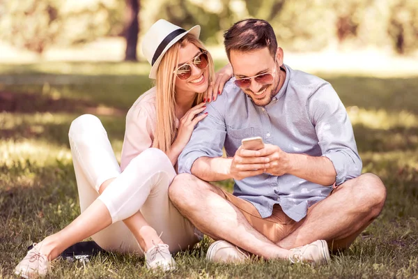 Junges Paar Mit Smartphone Einem Park Sitzend — Stockfoto