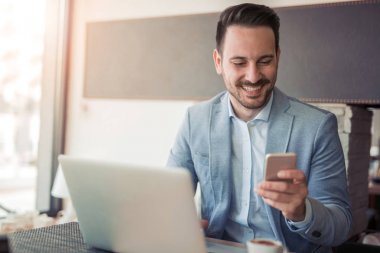 Ofis Masası, dizüstü bilgisayar üzerinde çalışan yakışıklı genç işadamı portresi.