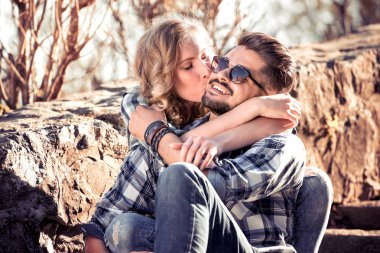 Merdivenlerden bir parkta oturan güzel genç bir çift. Aşk, aşk, sevinç ve mutluluk kavramı.