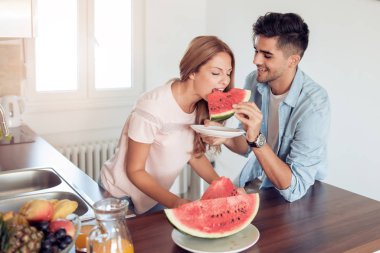 Mutfakta çalışan çift, sağlıklı gıda hazırlama çift mutfakta taze meyve yiyin.