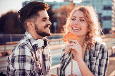 Mutlu genç çift dışarıda eğleniyor ve gülümsüyor..