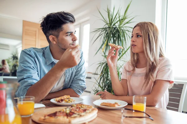 Молодая Улыбающаяся Пара Ест Домашнюю Пиццу Дома — стоковое фото