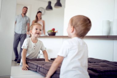 ayakta ve ayna ve ailesi onun yansıması izlerken küçük çocuk