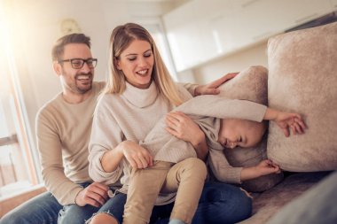 Mutlu aile, anne ve baba ile oğlu evde oynarken