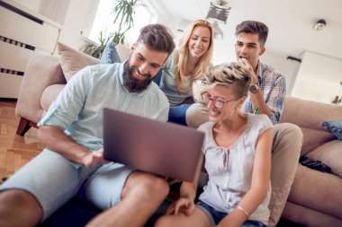 mutlu genç arkadaşlar evde istirahat ve dizüstü bilgisayar tarama