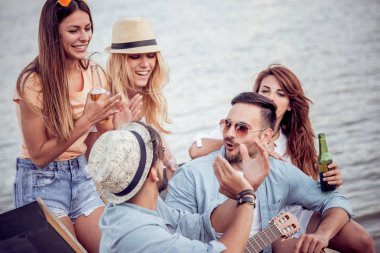 Birlikte şarkı ve gitar kumsalda oynarken zevk arkadaş