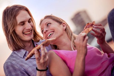 mutlu çift gülüyor ve pizza açık yemek
