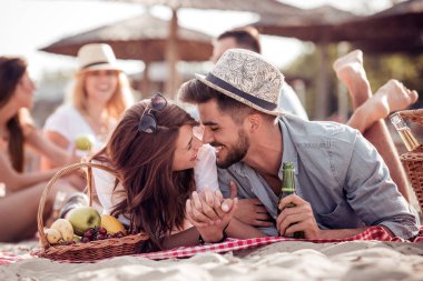 Mutlu genç çift zevk Kumsalda piknik ve yaz tatili iyi eğlenceler