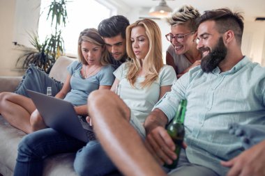 Grup genç arkadaşlar evde laptop tarama