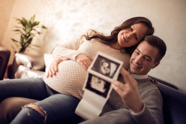 Mutlu adam onların ev gülümseyen hamile kadının göbek dokunmadan.