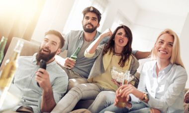 Arkadaşlar bira ve patlamış mısır ile Tv izlerken neşeli grup 