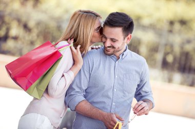 Mutlu genç çift alışveriş sonra şehirde yürüyüş