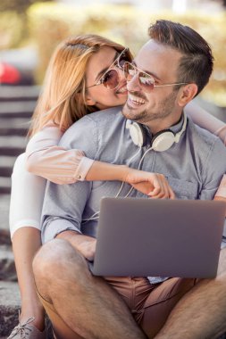 Genç çift merdiven üstünde laptop video izlerken