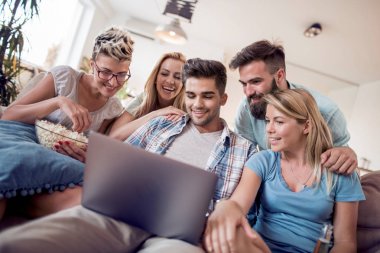 Grup genç arkadaşlar evde laptop tarama