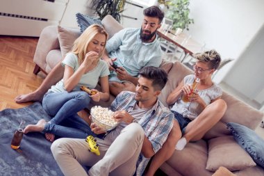 Patlamış mısır yemek ve ev iç bira içme mutlu genç arkadaş grubu