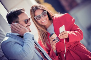 Mutlu çift kulaklık smartphone sokakta müzik paylaşımı ile