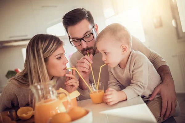 Ευτυχισμένη Οικογένεια Πίνοντας Χυμό Πορτοκάλι Στην Κουζίνα — Φωτογραφία Αρχείου